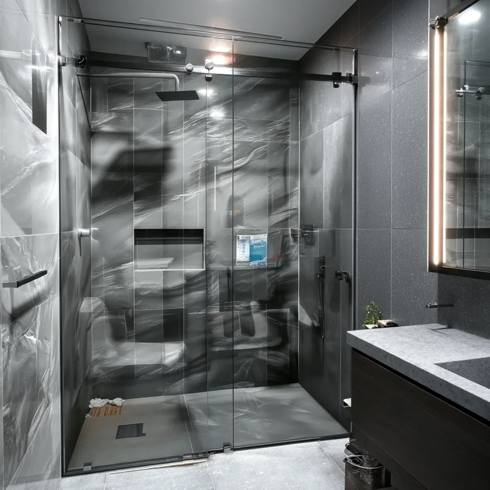 Baño gris con cancel de cristal templado y perfilería de aluminio