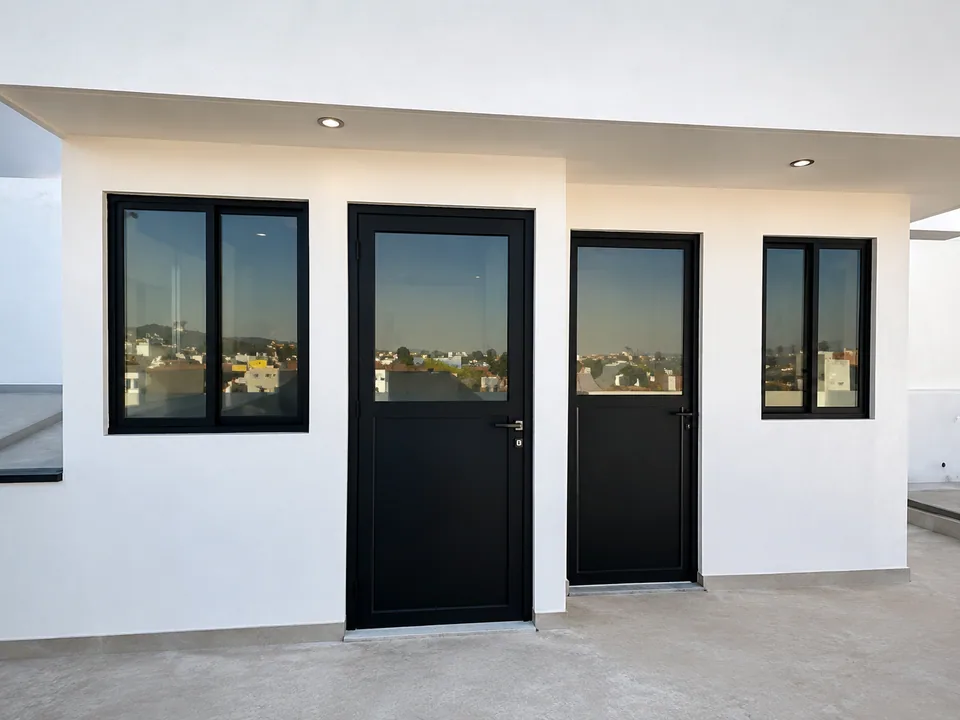 Fachada de casa blanca con cancelería de aluminio en Perote, Veracruz